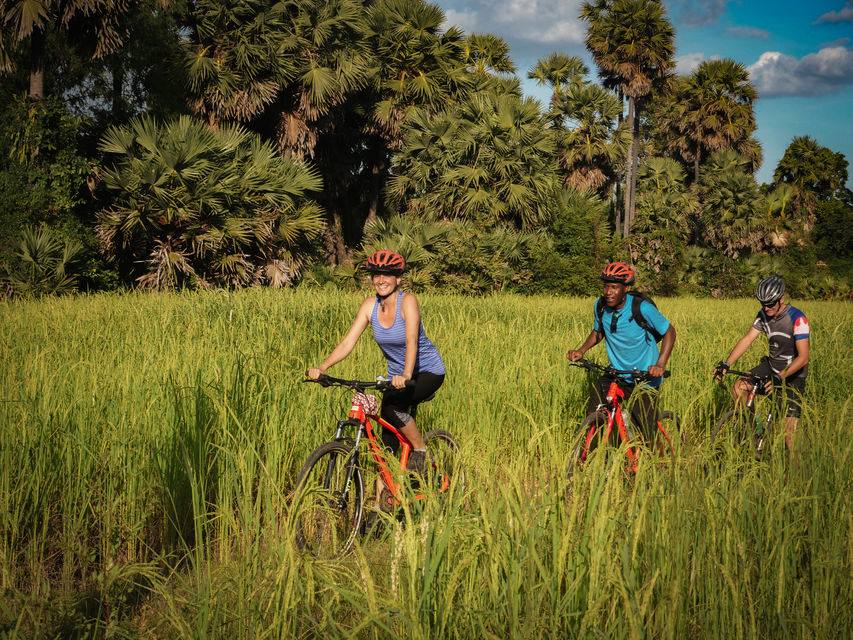 Three people cycling the surroundings of Siem Reap